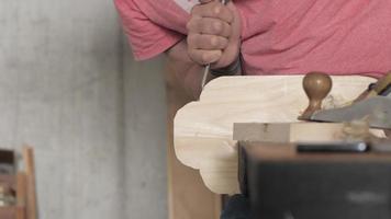houtbewerker snijdt overtollig af op een houten plank met een platte beitel video