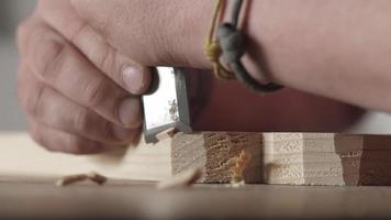 o entalhador corta as bordas de uma placa de madeira com um cinzel