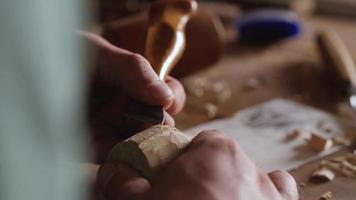 woodcarver carves a helmet of a robot with a knife video