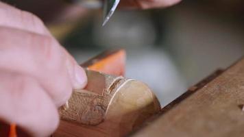 woodcarver carves a helmet of a robot video