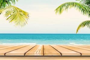 Empty wooden table and palm leaves background in summer time. photo