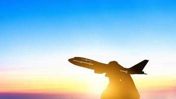 Miniature toy airplane flying on sunset background photo