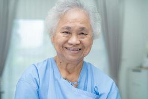 Paciente mujer senior asiática sonrisa cara brillante en el hospital de enfermería foto