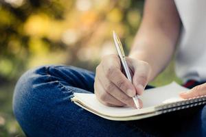 Cerrar las mujeres jóvenes escribiendo en un portátil en el parque
