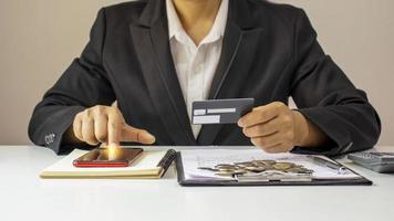 Mujer asiática pagando con tarjeta de crédito en línea mientras realiza pedidos en línea en casa, idea de transacción mediante la aplicación de banca móvil. foto