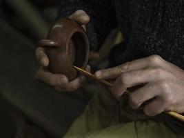 the craftsman makes a traditional Chinese teapot from Yixing clay photo