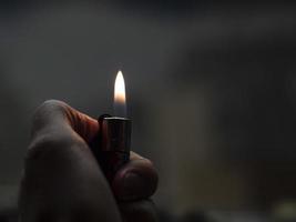 Men's hands hold lighters, fire from cigarette. photo