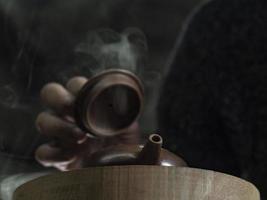 close-up male hand opens the lid of a clay teapot photo