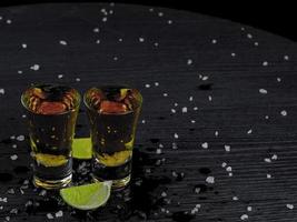 Two shots tequila gold with juicy lime photo