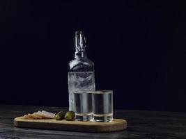 botella de vodka, dos vasos empañados con vodka frío foto