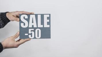 Close Up Of Man Hands Holding A Sign Saying Sale -50