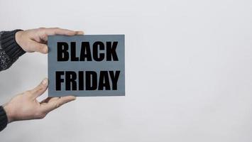 Close Up Of Man Hands Holding A Sign Saying Black Friday photo