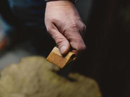 a man holding a handmade beard comb in his hand photo