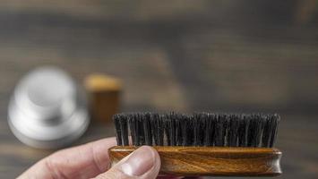 Cepillo de barba en una mano masculina sobre un fondo borroso foto