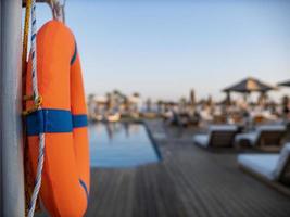 Orange lifebuoy near public swimming pool photo