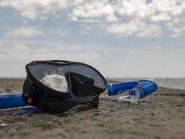 black diving mask and snorkel on a concrete pier photo