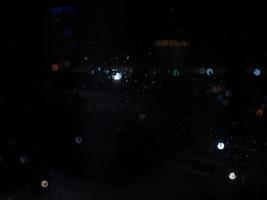 Rain drops on window with street bokeh lights photo