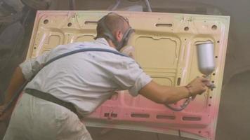 Proceso de pintura de automóviles en el taller, trabajador en máscara video