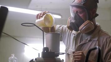 Process of car painting in workshop, worker in mask video