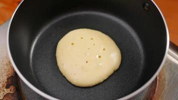 panqueca caseira em uma panela antiaderente cozinhando uma refeição deliciosa de café da manhã. video