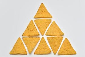 Chips de tortilla amarillo sobre fondo blanco. foto