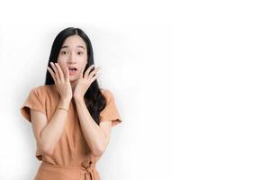 cara de sorpresa de mujer asiática en blanco aislado. pelo largo y negro foto