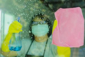 mujer rociando y limpiando vidrio foto