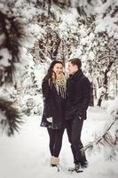 chico y una chica en ropa y bufandas en un paseo en el clima nevado foto