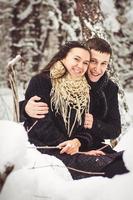 Guy and a girl in clothes and scarves on a walk in the snowy weather photo