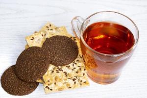 Glass cup with hot tea and a bunch of dry biscuits photo
