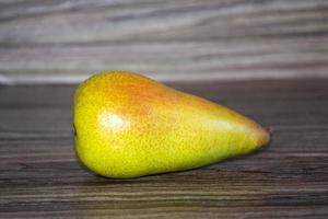 Yellow long pear lies on a wooden background photo