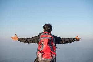 Man traveling with backpack hiking in mountains photo