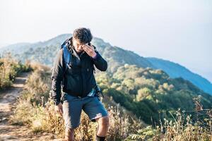 Man traveling with backpack hiking in mountains photo