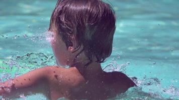 um menino brinca na piscina de um hotel resort.