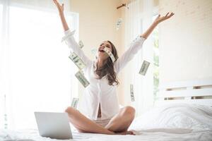 Woman with dollar bank note on the bed photo