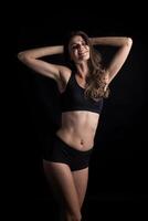 Beautiful woman with healthy body on black background photo