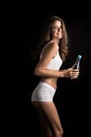 Female fitness model holding a water bottle photo