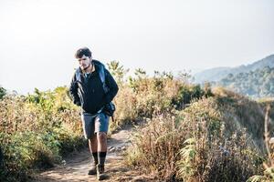 Hombre que viaja con mochila de senderismo en las montañas foto