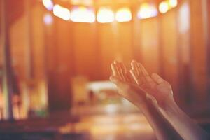 Young woman's hands clasped in prayer at christ church photo