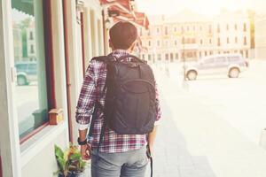 Rear of young traveler with backpack on an adventure vacation photo