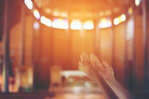 Young woman's hands clasped in prayer at christ church photo