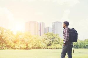 Young hipster man enjoys the town view from park while traveling photo