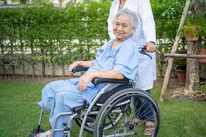 Doctor help and care Asian senior woman patient sitting on wheelchair photo