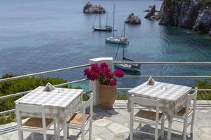 Restaurant tables waiting for customers by the sea outdoor terrace. photo