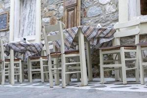 White chairs and white tables in traditonal greek style photo