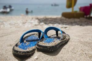 chanclas azules en la playa foto