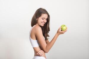 Belleza mujer sosteniendo manzana verde mientras aislado en blanco foto