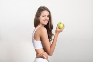 Belleza mujer sosteniendo manzana verde mientras aislado en blanco foto