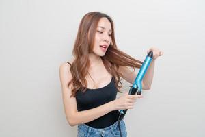 Portrait beautiful Asian woman using hair curler or curling iron on white background photo