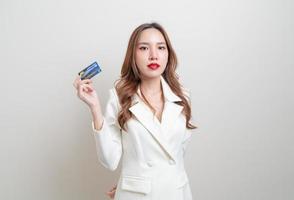 Retrato hermosa mujer asiática con tarjeta de crédito sobre fondo blanco. foto